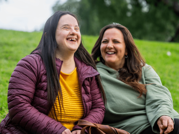 https://www.ablenow.com/uploads/articles/Two_women_one_with_down_syndrome_sit_in_a_park_laughing-1000x750-min.png
